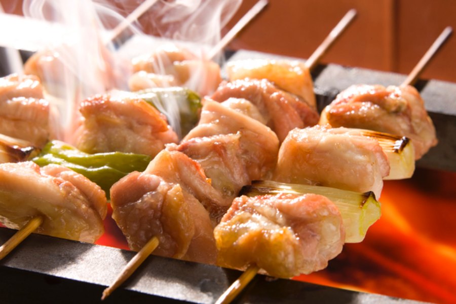 숯불 위에서 노릇하게 익어가며 연기를 내뿜는 닭꼬치 구이